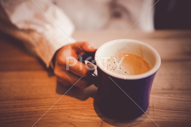 ホットコーヒーを飲む女性と手