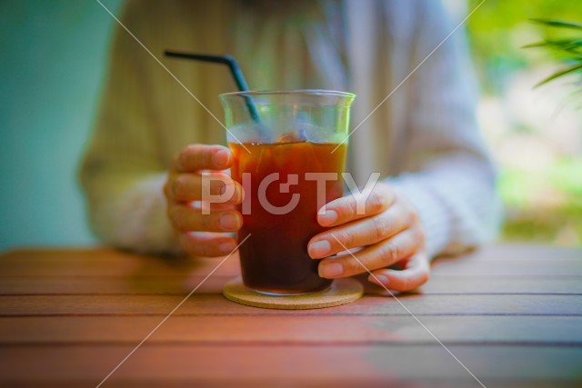 アイスコーヒーを飲む女性のイメージ
