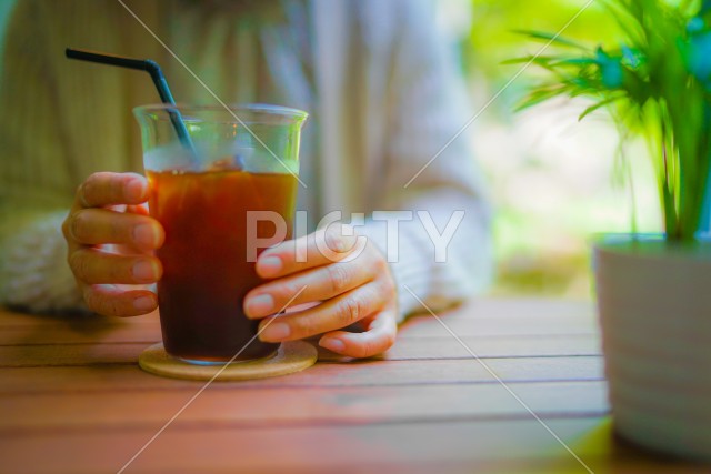 アイスコーヒーを飲む女性のイメージ