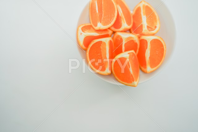 白い皿に載せられた複数のオレンジ