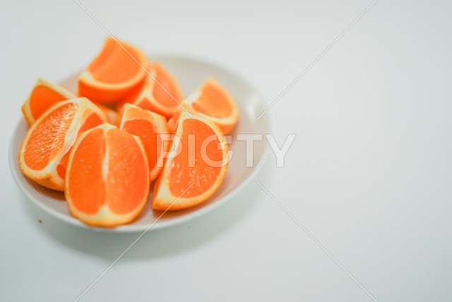 白い皿に載せられた複数のオレンジ