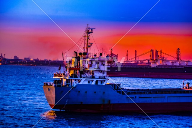 貨物船のシルエットと夕景