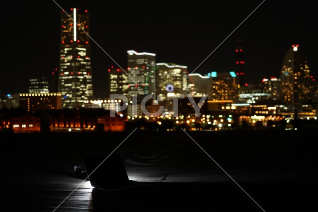 横浜の夜景とノートパソコン（ノマドワーカーのイメージ）