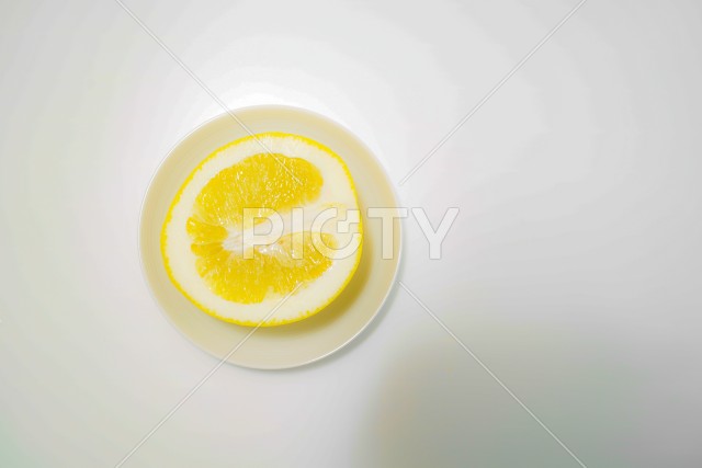 グレープフルーツと白い皿のイメージ