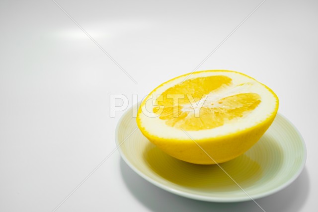 グレープフルーツと白い皿のイメージ