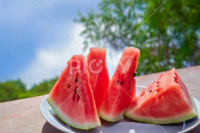 夏空を背景にお皿に盛られたスイカ