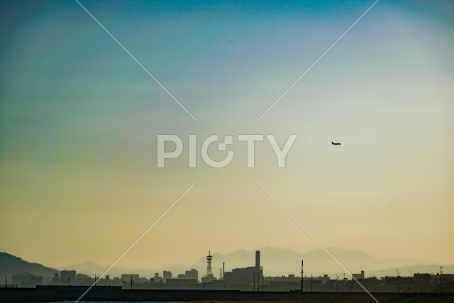 函館の街と夕暮れを飛ぶ飛行機