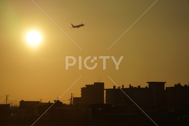 函館の街と夕暮れを飛ぶ飛行機