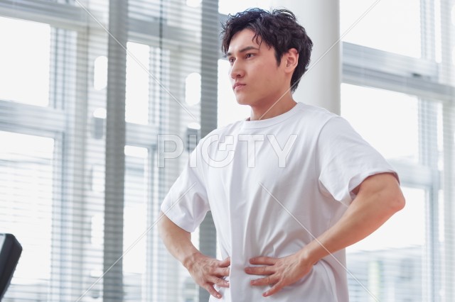 トレーニング施設で腹筋をさわっている男性
