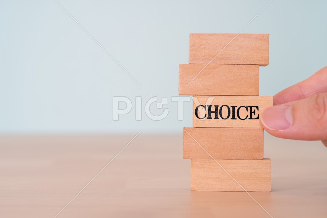 チョイス｜「CHOICE」と書かれた積み木とそれを持つ人の手