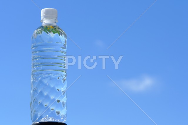 夏の青空背景のボトルと水