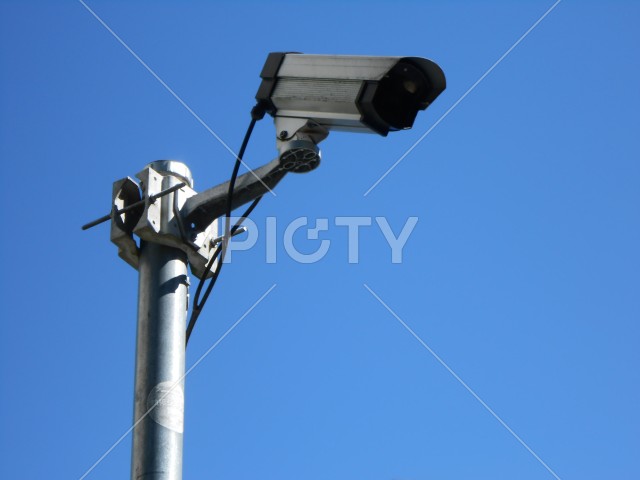 青空にそそり立つ防犯監視カメラ