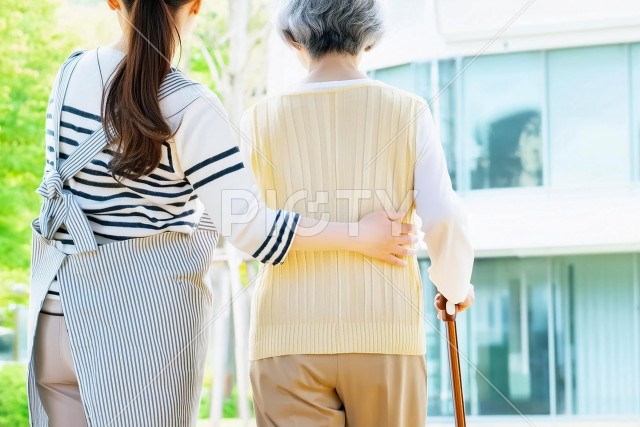 お年寄りの歩行を介助する女性介護士