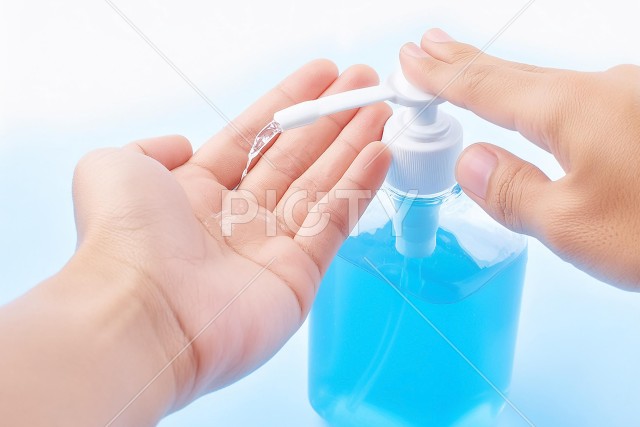消毒液をかける手