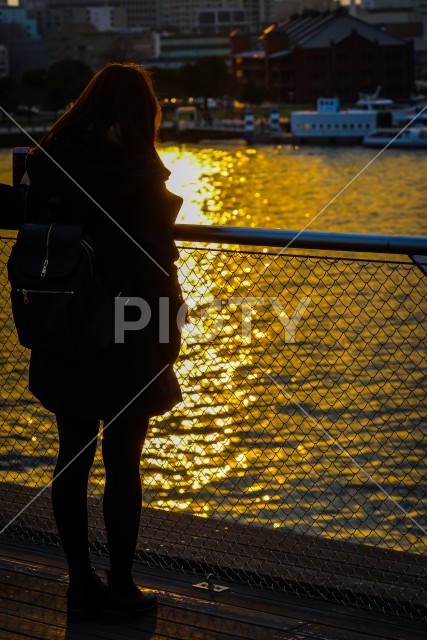 夕暮れの大桟橋に立つ女性